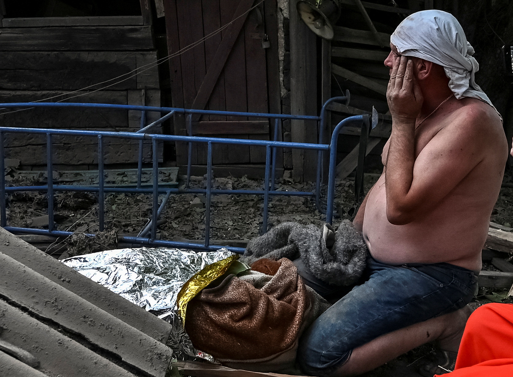 Мужчина рядом с телом своего убитого 11-летнего сына. Чаплино, Днепропетровская область. 24 августа 2022 года. REUTERS/Dmytro Smolienko/Scanpix/LETA