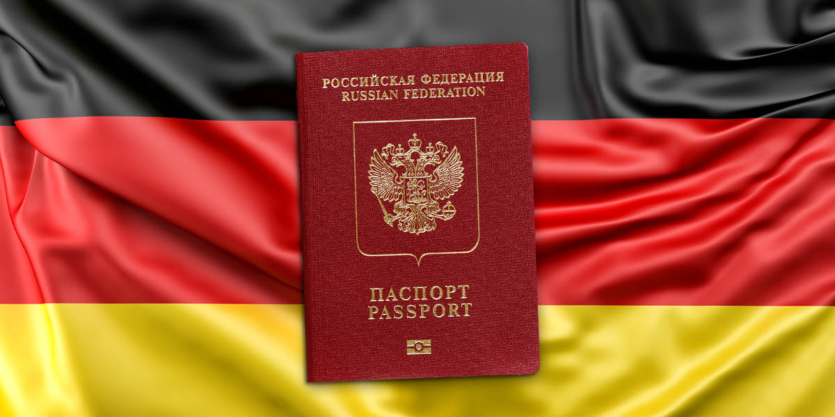 Загранпаспорт РФ на фоне флага Германии. Фото флага по лицензии Freepik. Иллюстрация Spektr.press