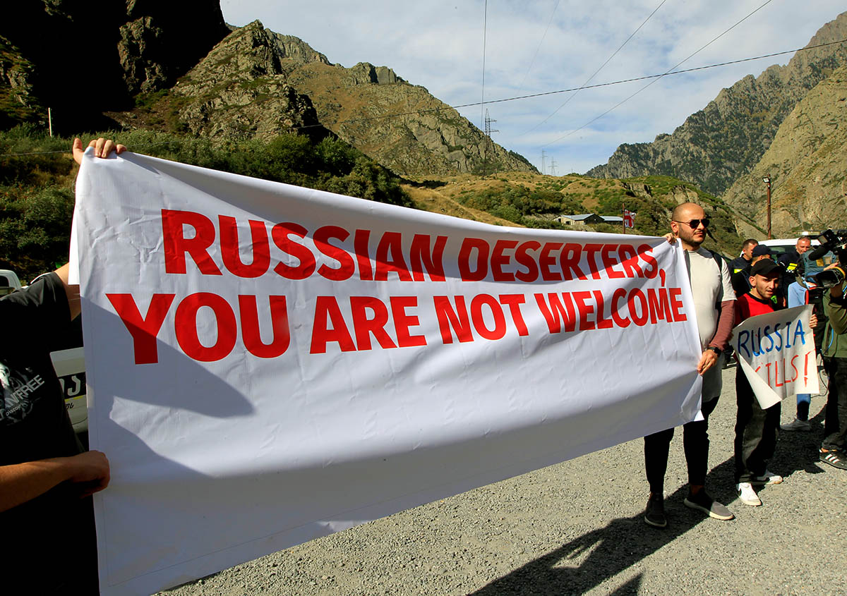 Активисты держат антироссийский транспарант возле пограничного перехода между Грузией и Россией в Грузии. 28 сентября 2022 года. Фото Shakh Aivazov/AP/Scanpix/LETA  