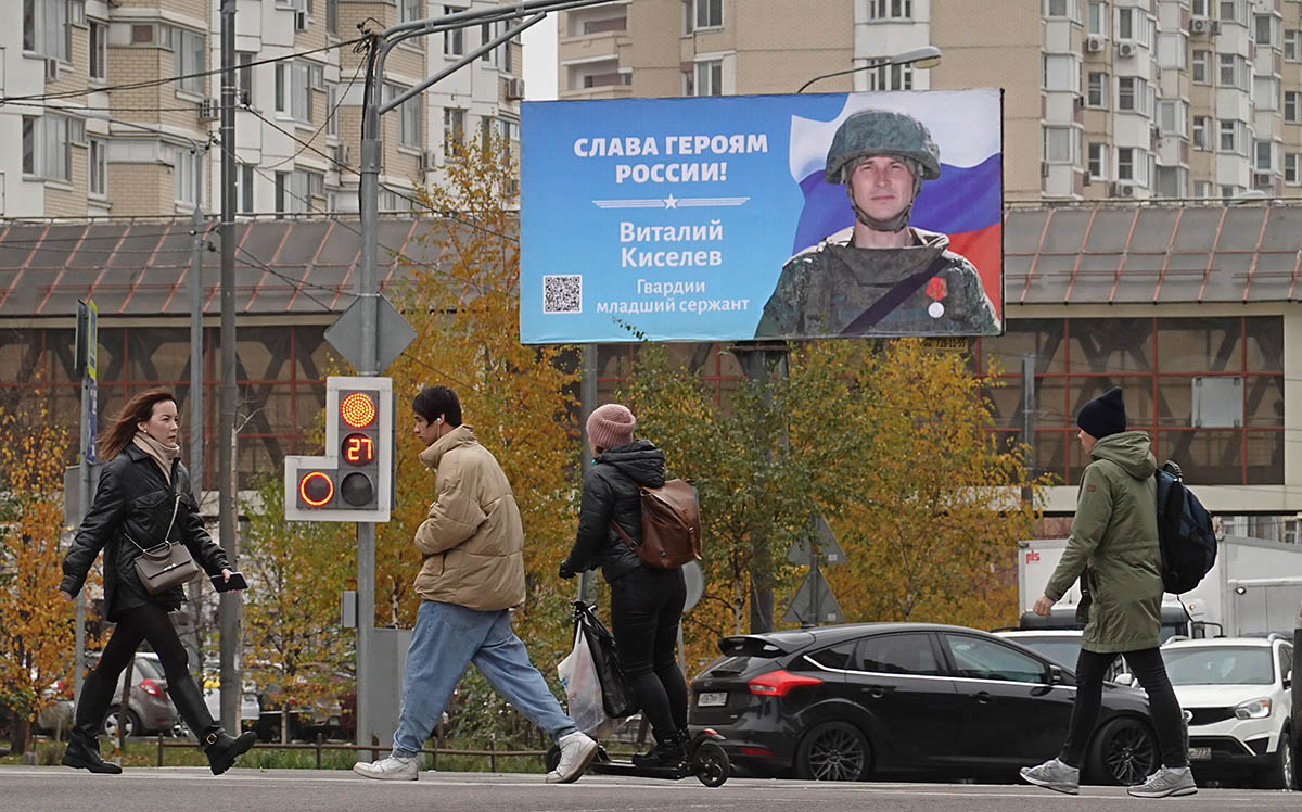 Люди проходят мимо рекламного щита с лозунгом «Слава героям России!» в Москве. Фото MAXIM SHIPENKOV/EPA/Scanpix/Leta
