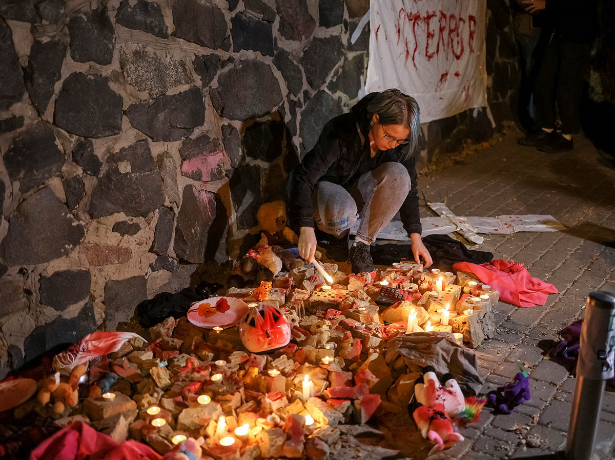 Активист зажигает свечу в память о людях, погибших в результате удара российского беспилотника в Киеве, Украина. 17 октября 2022 года. Фото Gleb Garanich/REUTERS/Scanpix/Leta