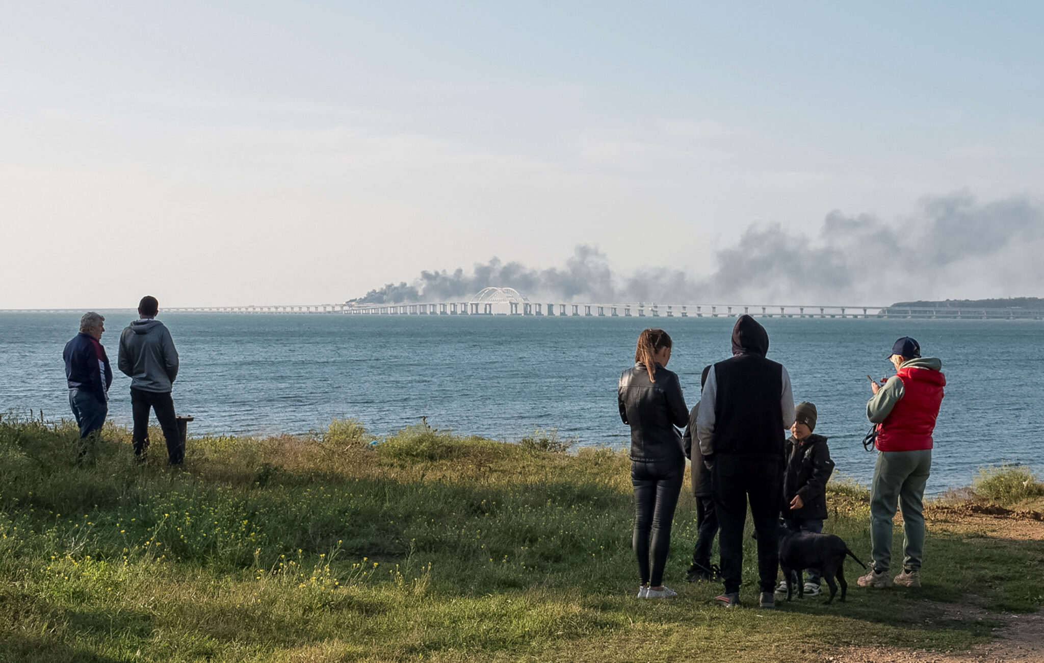 Люди смотрят на пожар на Крымском мосту. Фото Reuters/Scanpix/Leta