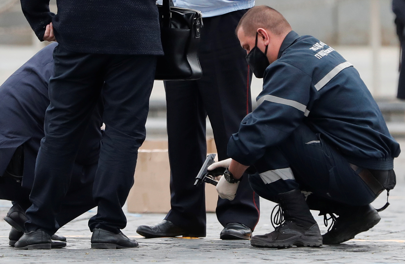 Сотрудники полиции изучают пистолет, предположительно, использовавшийся художником Павлом Крисевичем во время его перформанса на Красной площади. Фото REUTERS/Shamil Zhumatov/Scanpix/Leta