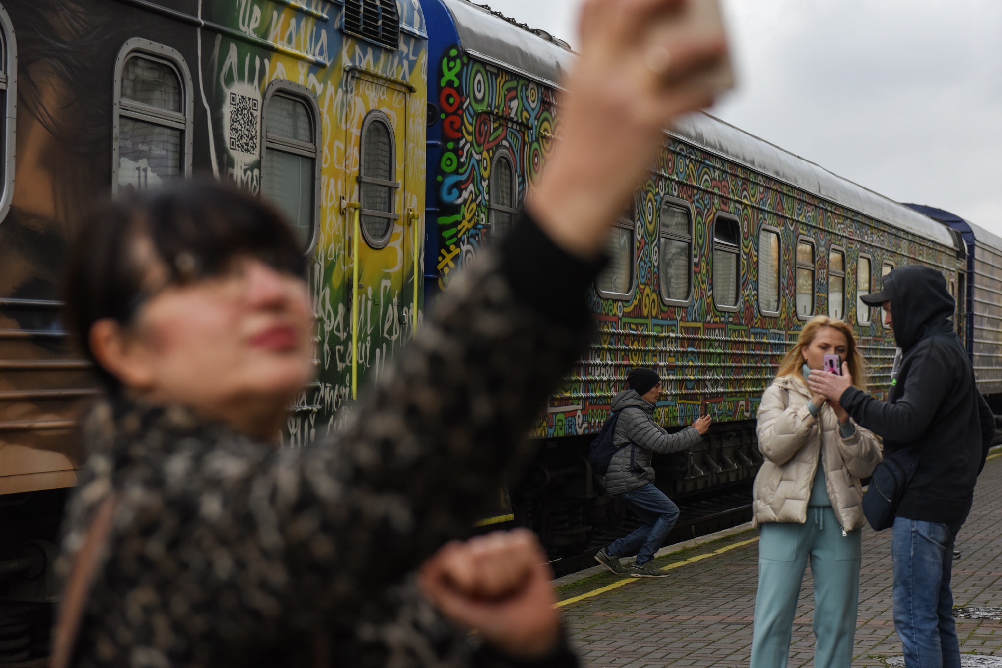 Люди делают селфи на фоне первого поезда прибывшего в Херсон из Киева с момента вторжения армии РФ в Украину. Фото EPA/OLEG PETRASYUK/Scanpix/Leta.