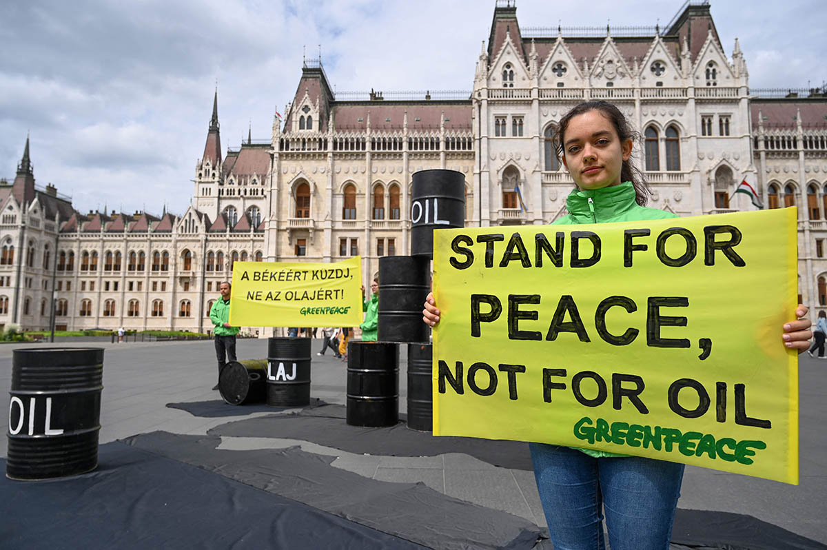 Плакат «Стоять за мир, а не за нефть» перед зданием парламента в Будапеште, Венгрия. Фото ATTILA KISBENEDEK/AFP/Scanpix/LETA