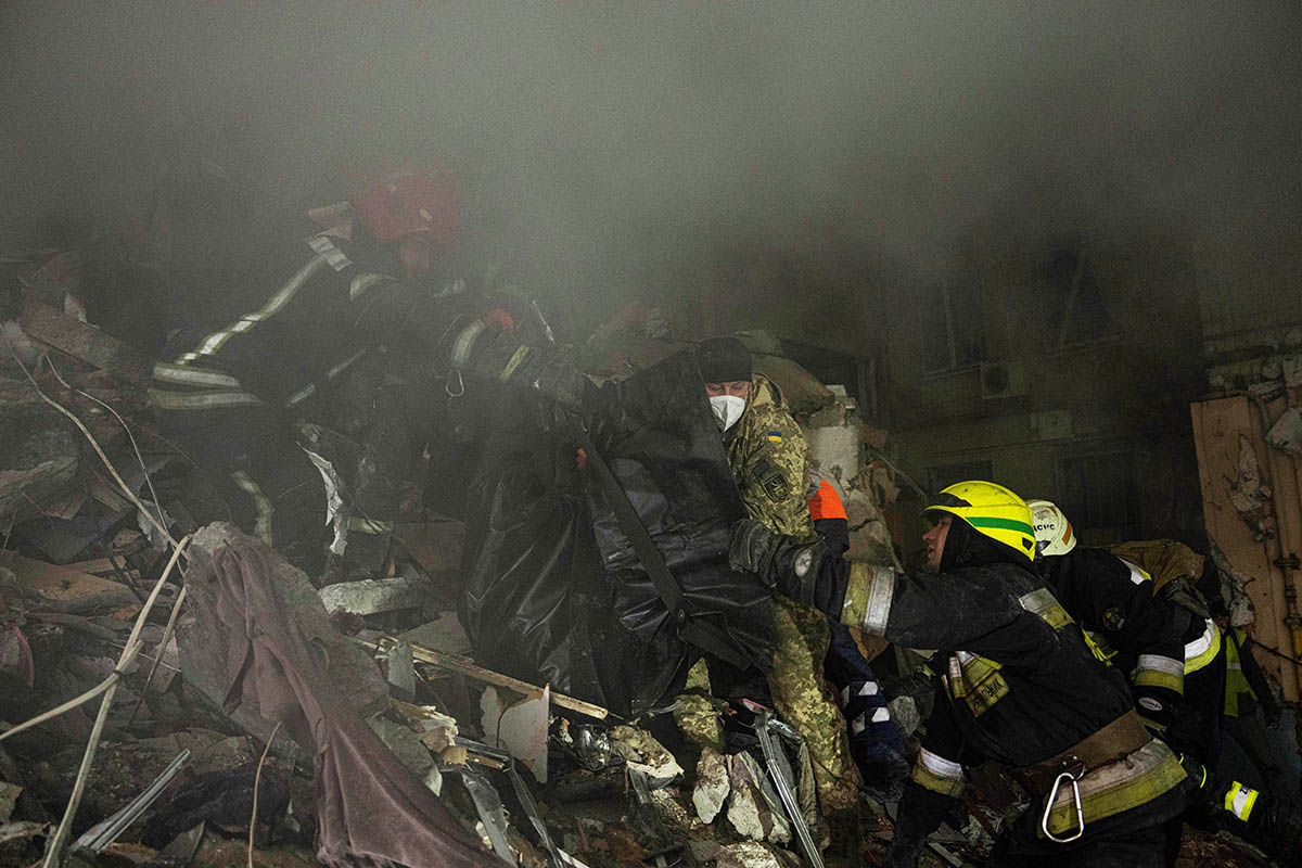 Спасатели спускают тело мужчины, погибшего в результате российского ракетного удара по многоквартирному дому в Днепре, Украина. Фото Evgeniy Maloletka/AP Photo/Scanpix/LETA