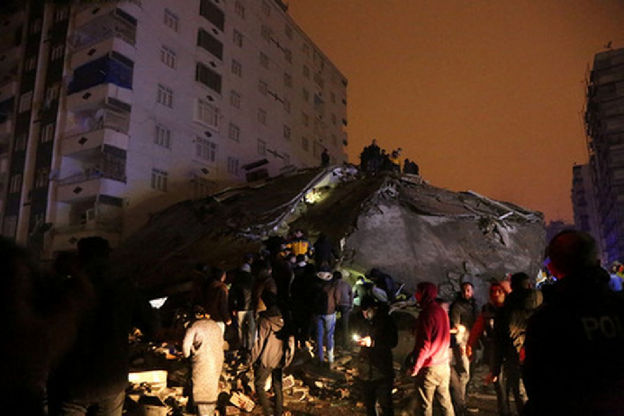 Люди на развалинах разрушенного дома в городе Диярбакыр в Турции. Фото Sertac Kayar/Reuters/Scanpix/LETA