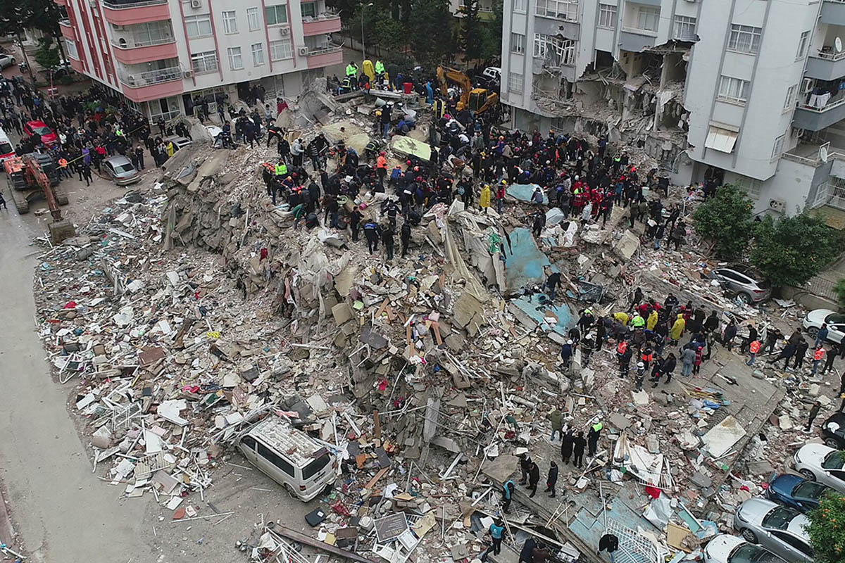 Люди на развалинах разрушенного в результате землетрясения дома в городе в Адане, Турция. 6 февраля 2023 года. Фото  REUTERS/Scanpix/LETA