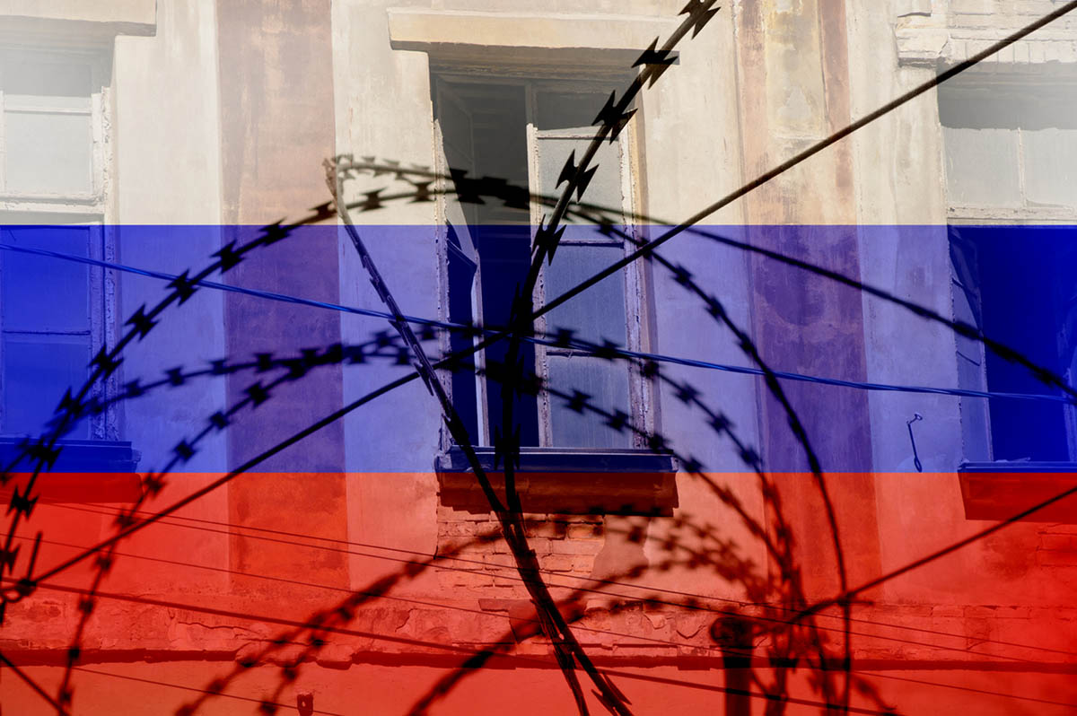 Флаг России на фоне колючей проволоки. Фото Victoria Kotlyarchuk по лицензии Istockphoto