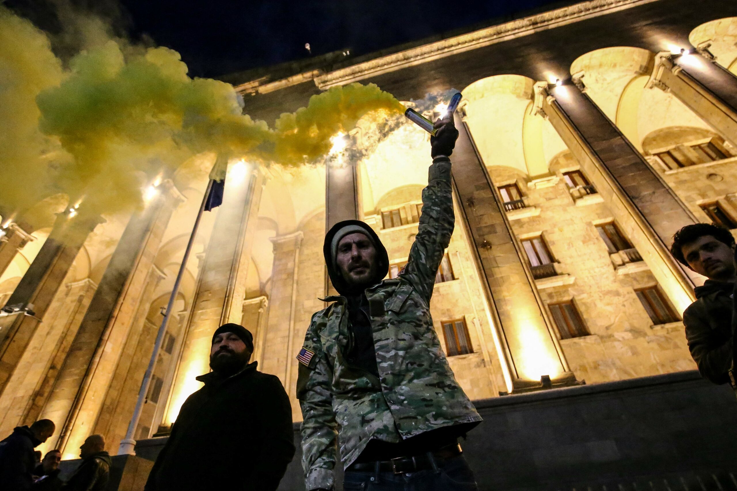 Протестующий держит дымовую шашку перед зданием парламента Грузии в Тбилиси, 7 марта 2023 года. Фото STRINGER/AFP/Scanpix/LETA.