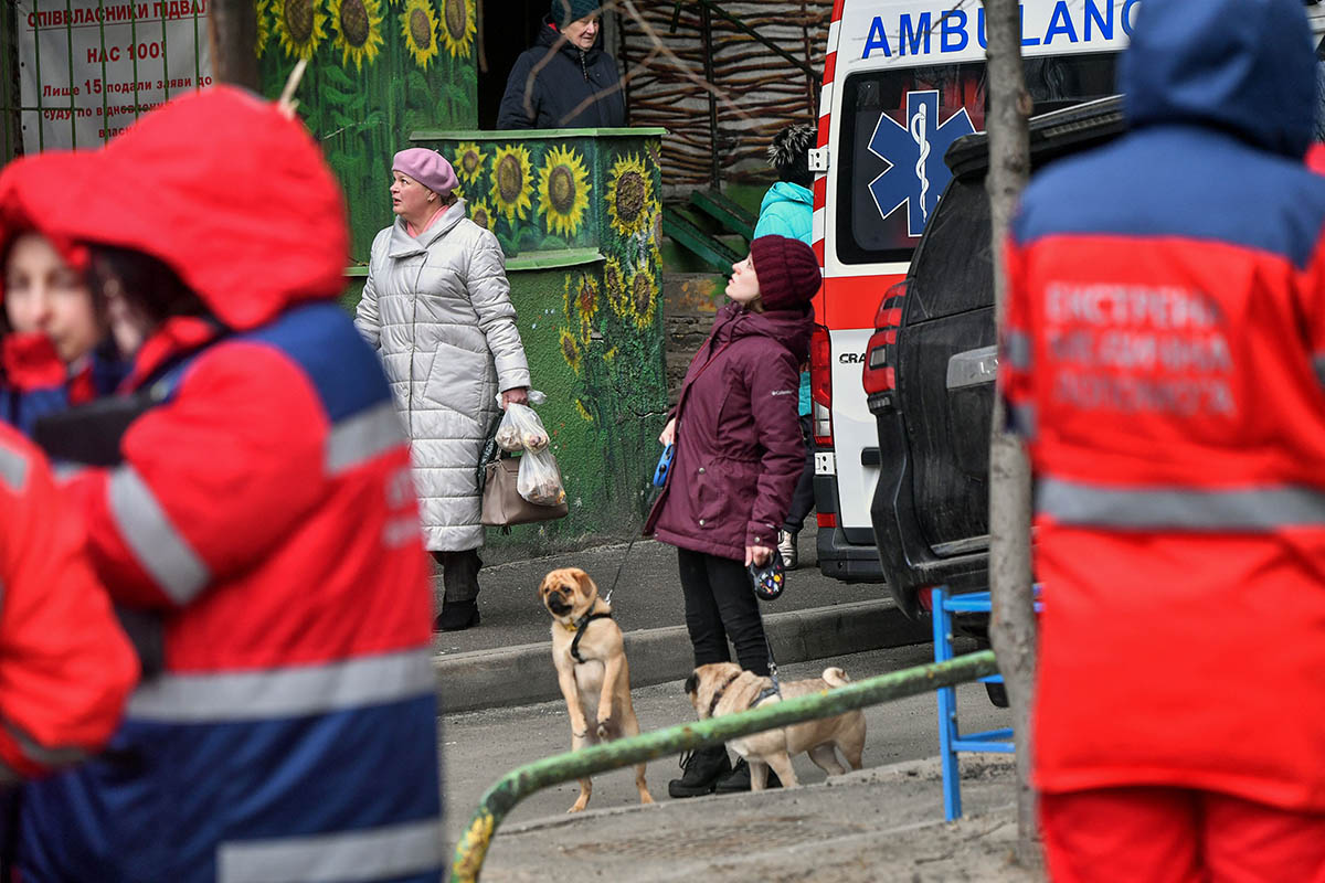Местные жители рядом с местом падения осколков российской ракеты, Киев. 9 марта 2023 года. Фото Sergei SUPINSKY/AFP/Scanpix/LETA