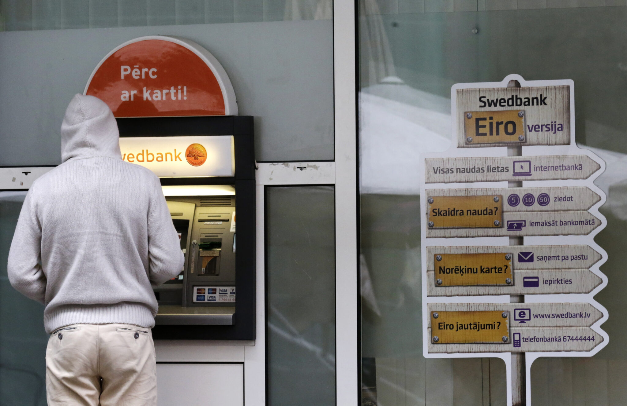 Человек у банкомата Swedbank. Фото Ints Kalnins/Reuters/Scanpix/Leta