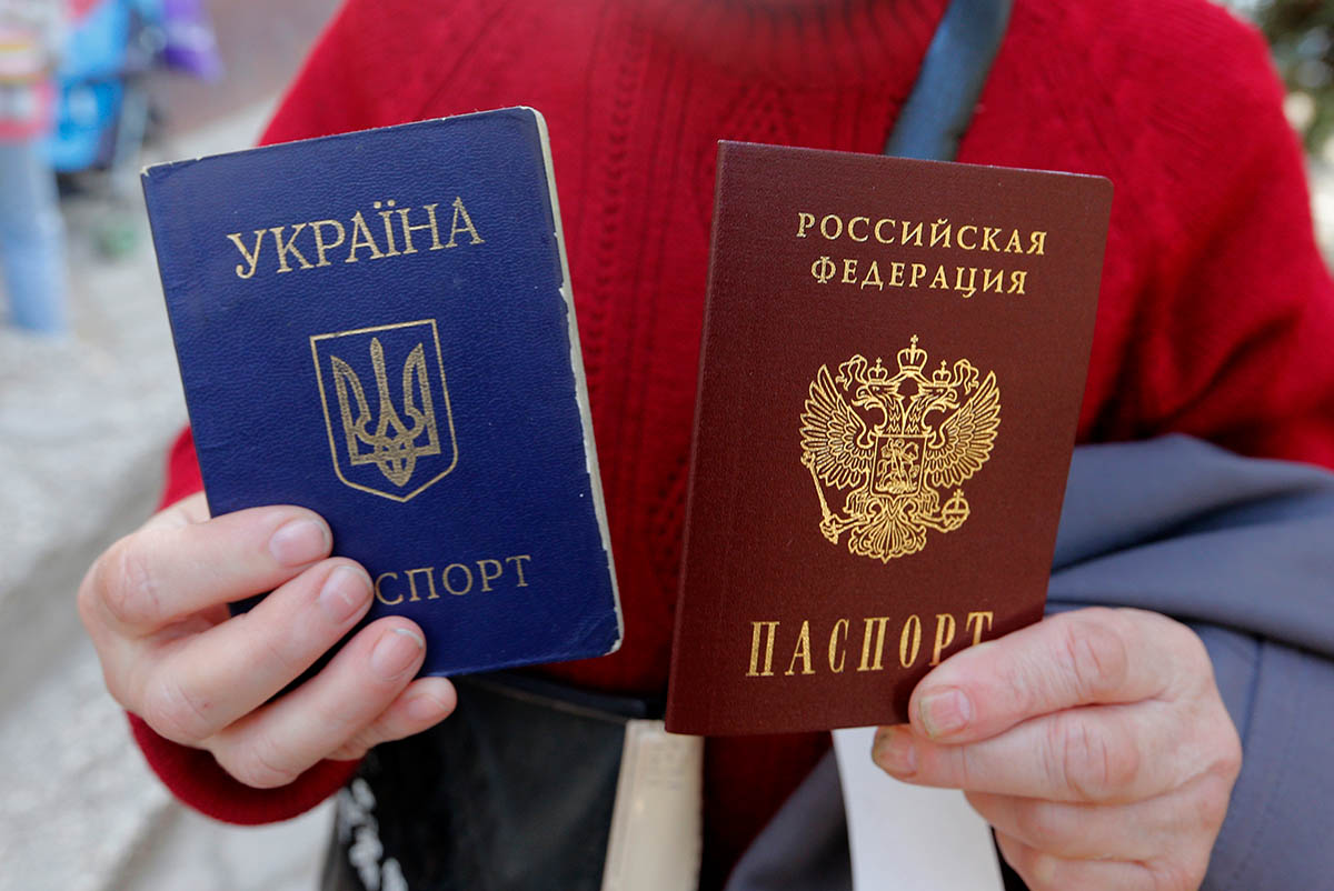 Женщина с украинским и российским паспортами возле офиса Федеральной миграционной службы России. Фото Maxim Shemetov/REUTERS/Scanpix/Leta