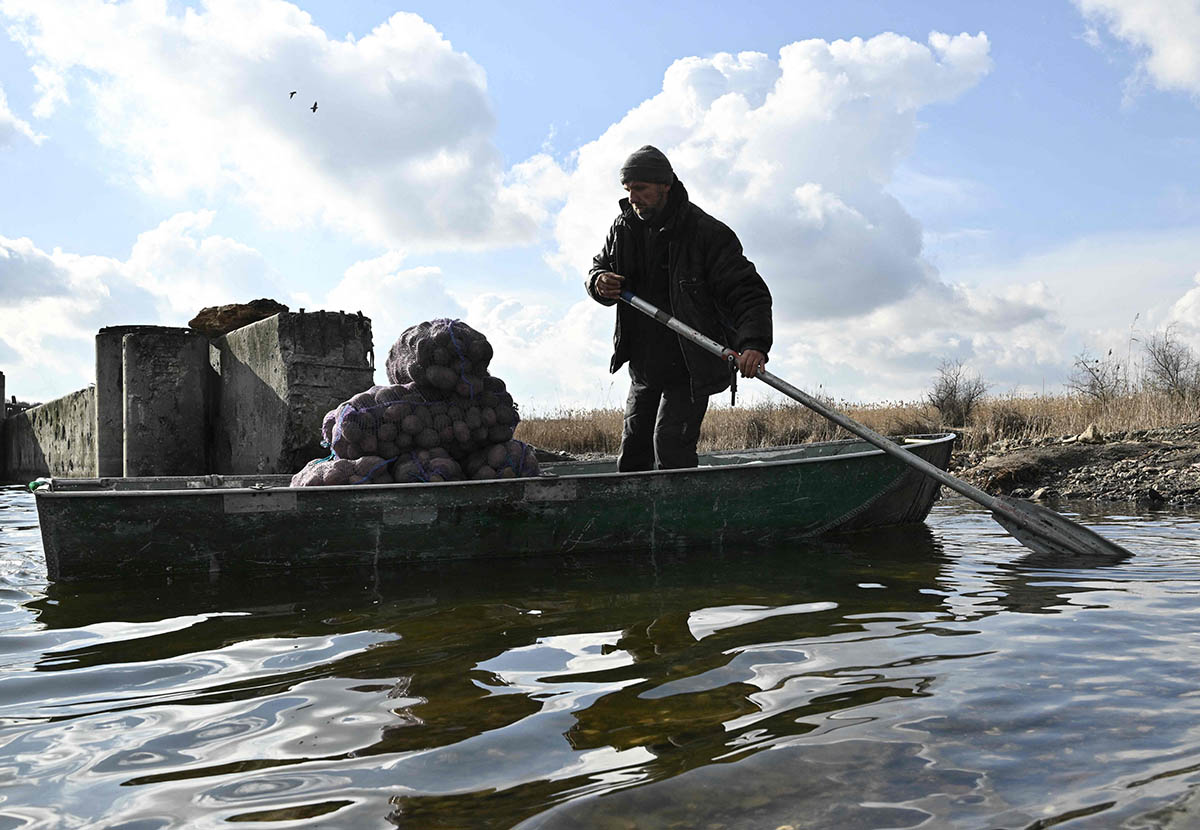 Местный житель переправляет мешки с картошкой через реку возле села Дарьевка Херсонской области. Фото Genya SAVILOV/AFP/Scanpix/Leta