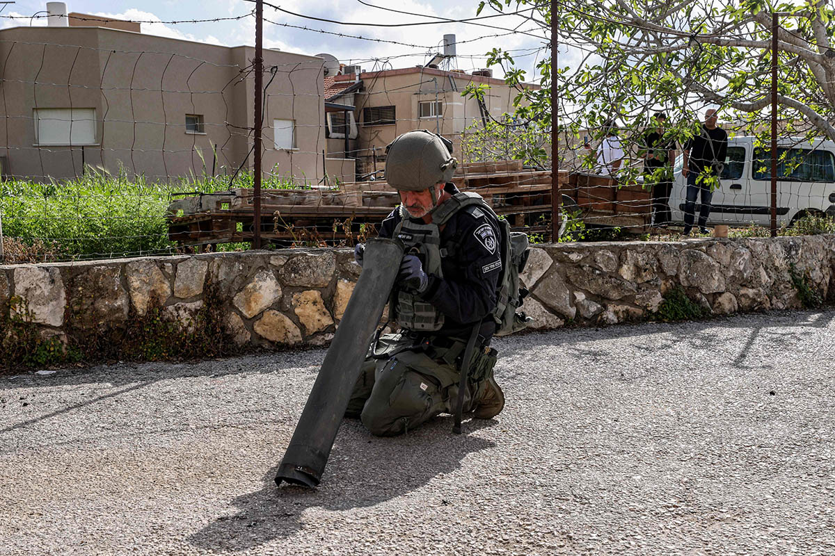 Сотрудник подразделения по обезвреживанию бомб израильской полиции осматривает остатки снаряда, выпущенного из Ливана. Фото Jalaa MAREY/AFP/Scanpix/LETA