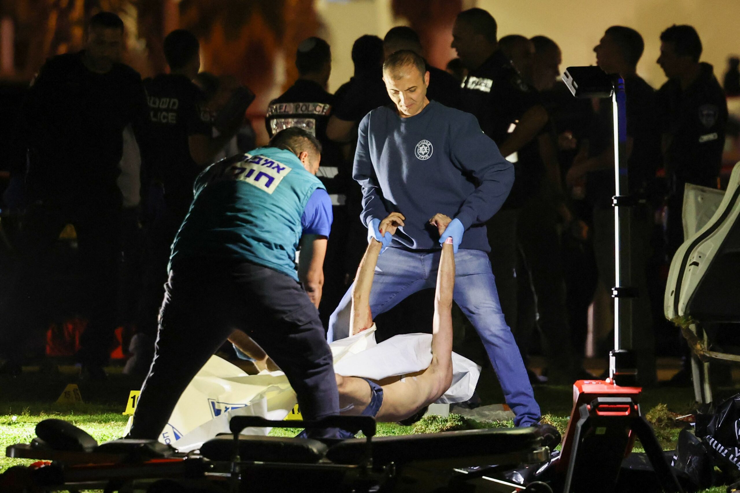 Израильская полиция убирает тело нападавшего с места нападения в Тель-Авиве 7 апреля 2023 года. Фото AHMAD GHARABLI / AFP / Scanpix / LETA.