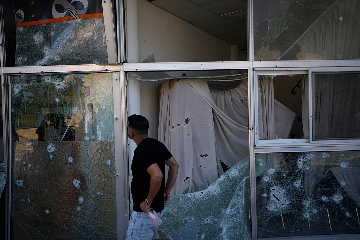 Мужчина осматривает повреждения торгового центра от сбитой ракеты, выпущенной из Ливана. Фото Ariel Schalit/AP Photo/Scanpix/LETA