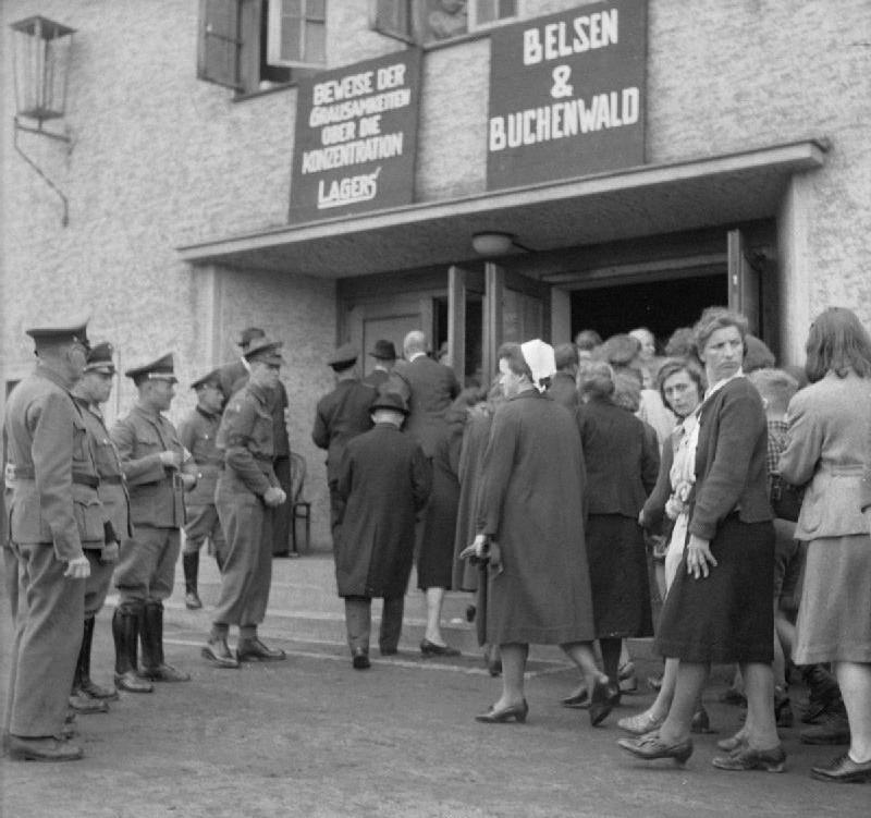 Британские военные и немецкие гражданские полицейские наблюдают за тем, как жители Бургштайнфурта входят в кинотеатр, чтобы посмотреть фильм, демонстрирующий сцены из концлагерей Бельзен и Бухенвальд. Фото из архива Имперского военного музея в Лондоне, Public Domain
