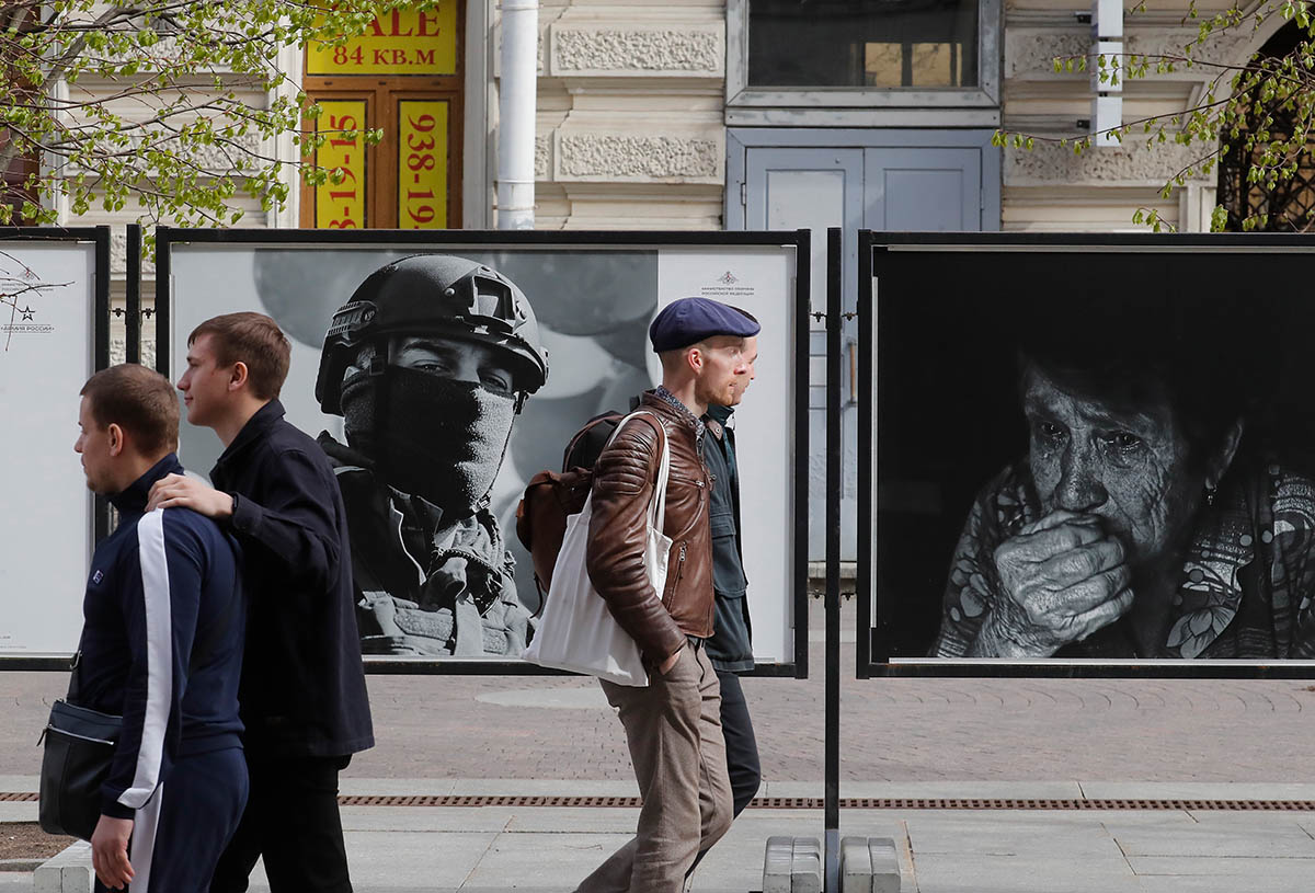 Люди проходят мимо уличной фотовыставки Минобороны России в Санкт-Петербурге. Фото ANATOLY MALTSEV/EPA/Scanpix/LETA
