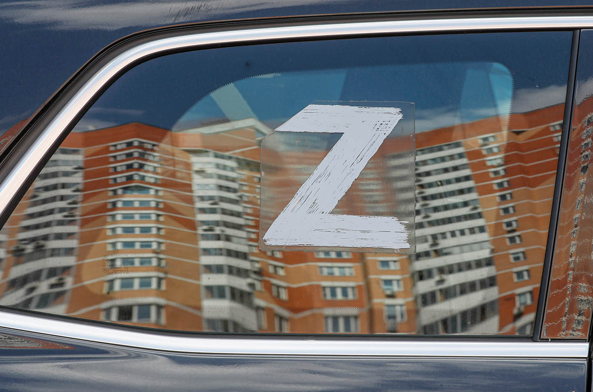 Поврежденный беспилотником жилой дом в Москве отражается в стекле автомобиля с буквой Z. Фото YURI KOCHETKOV/EPA/Scanpix/LETA