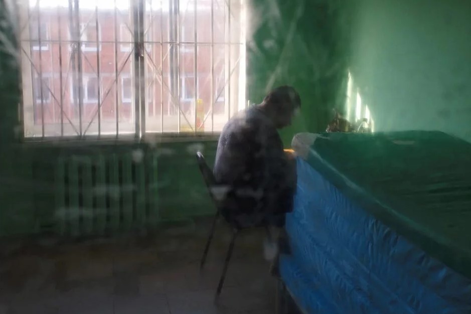 Пациент психоневрологического интерната в наблюдательном отделении за закрытой дверью. Фото с сайта opeka-pni.tilda.ws.