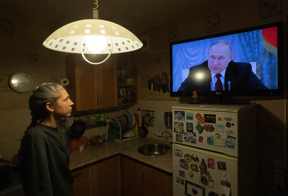 Женщина смотрит выступление Владимира Путина по телевизору. Фото Anatoly Maltsev/EPA/Scanpix/LETA