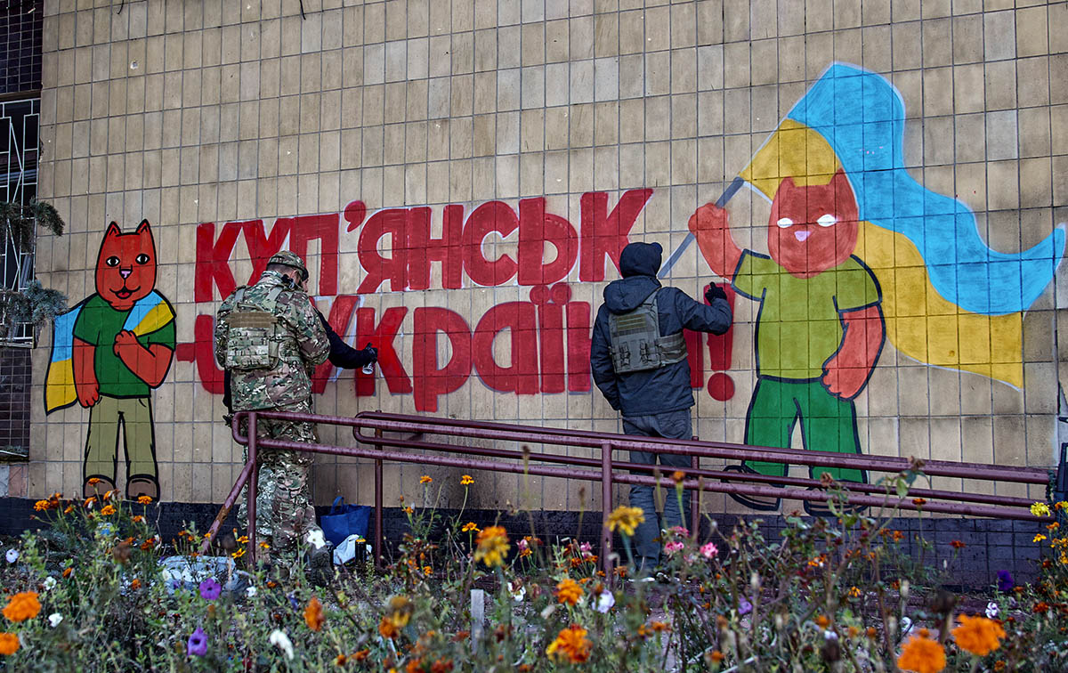 Группа украинских художников рисует граффити на стене в городе Купянск. Фото SERGEY KOZLOV/EPA/Scanpix/LETA