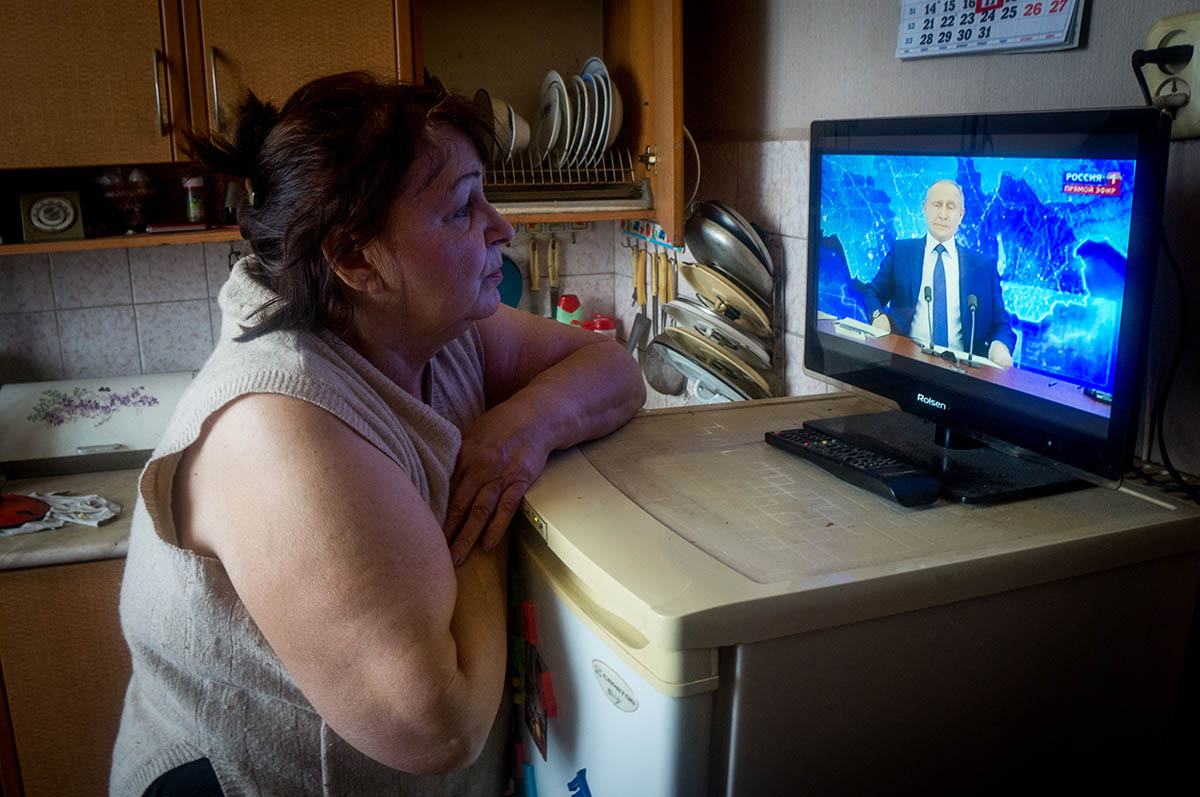 Женщина смотрит выступление Владимира Путина по телевизору. Фото Lev Vlasov/ZUMA Wire/Scanpix/LETA
