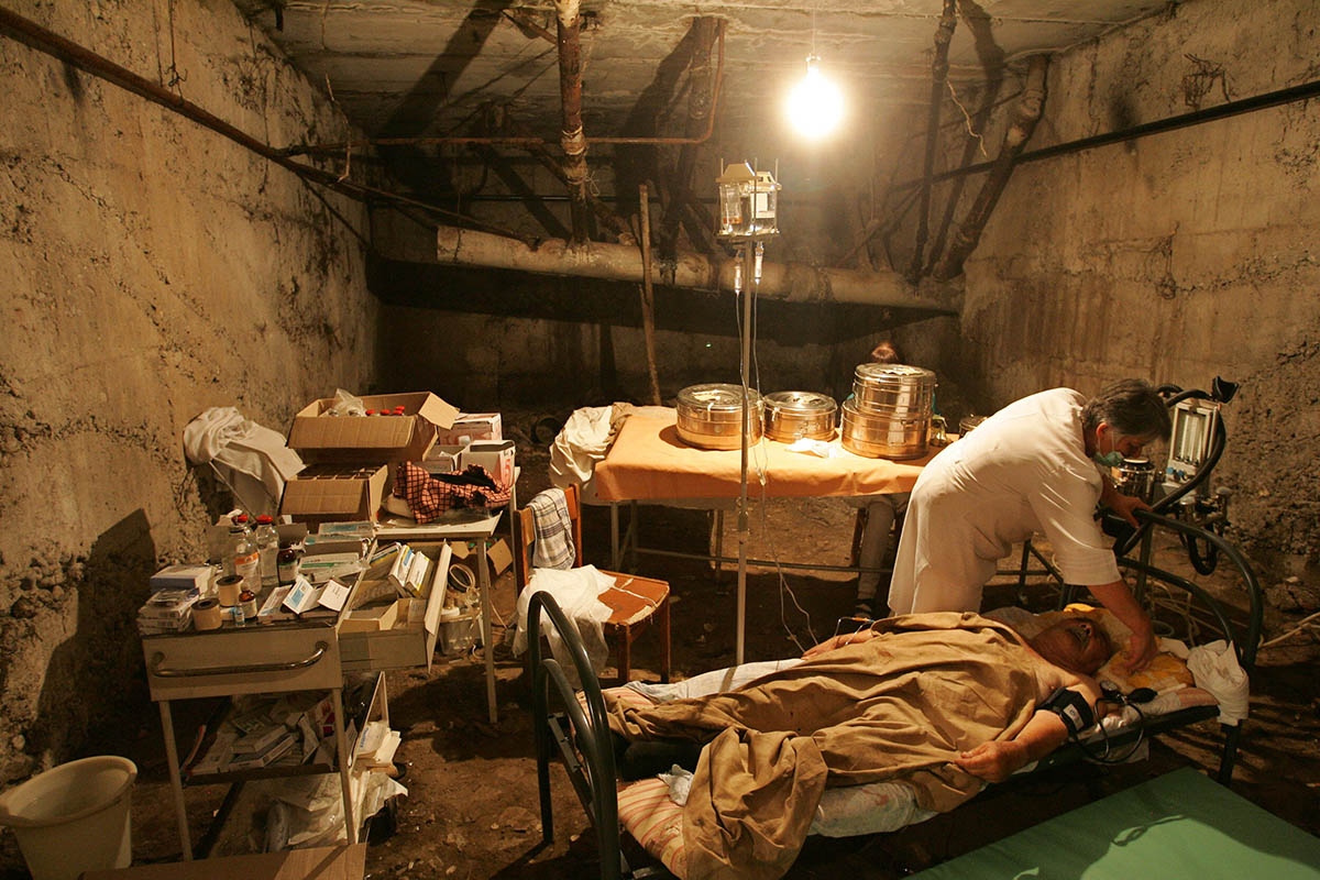 Югоосетинский врач рядом с раненым в подвале разрушенной больницы в Цхинвале, 10 августа 2008 года. Фото DMITRY KOSTYUKOV/AFP PHOTO/Scanpix/LETA