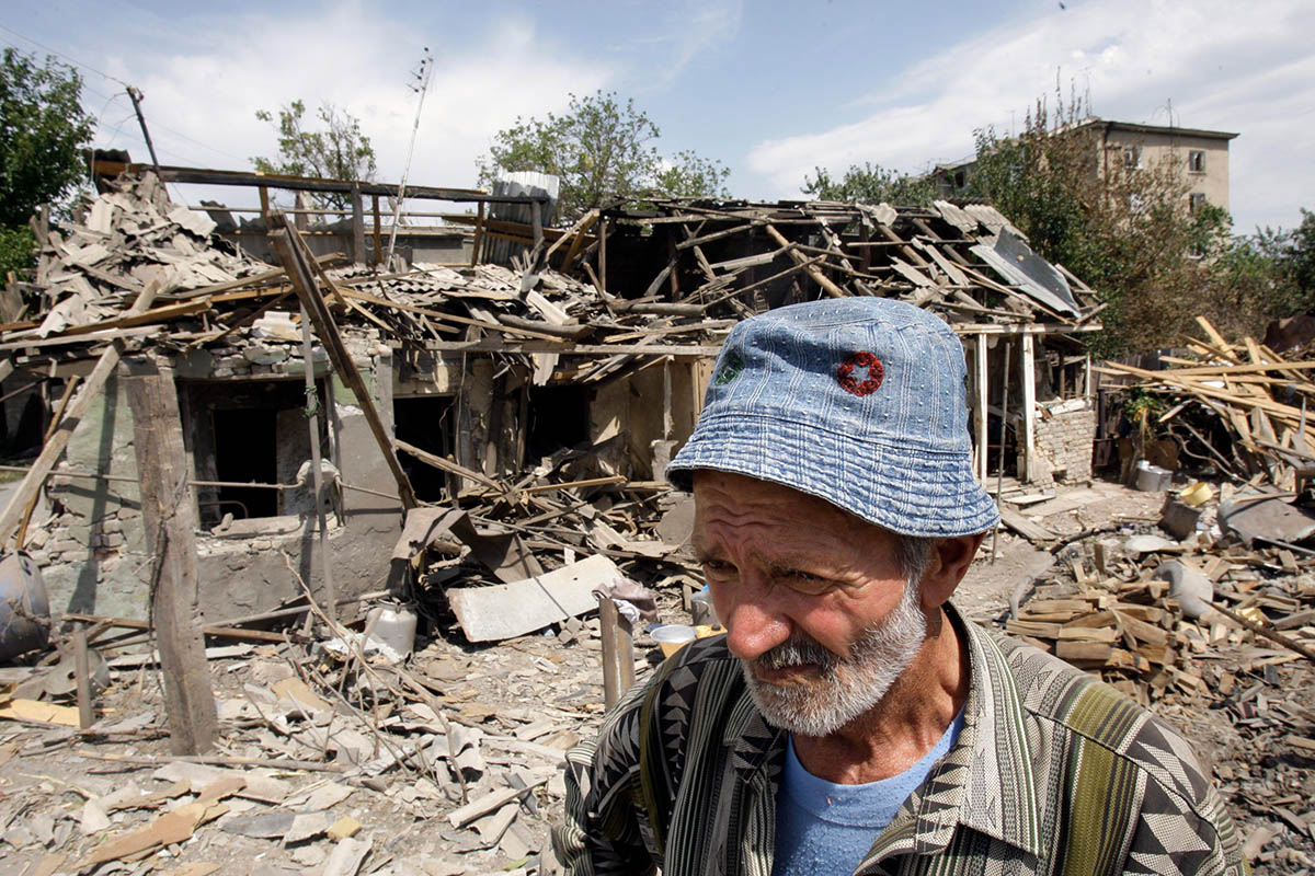 Житель Южной Осетии стоит у своего дома, разрушенного в результате обстрела грузинскими войсками в Цхинвали, 16 августа 2008 года. Фото Denis Sinyakov/REUTERS/Scanpix/LETA