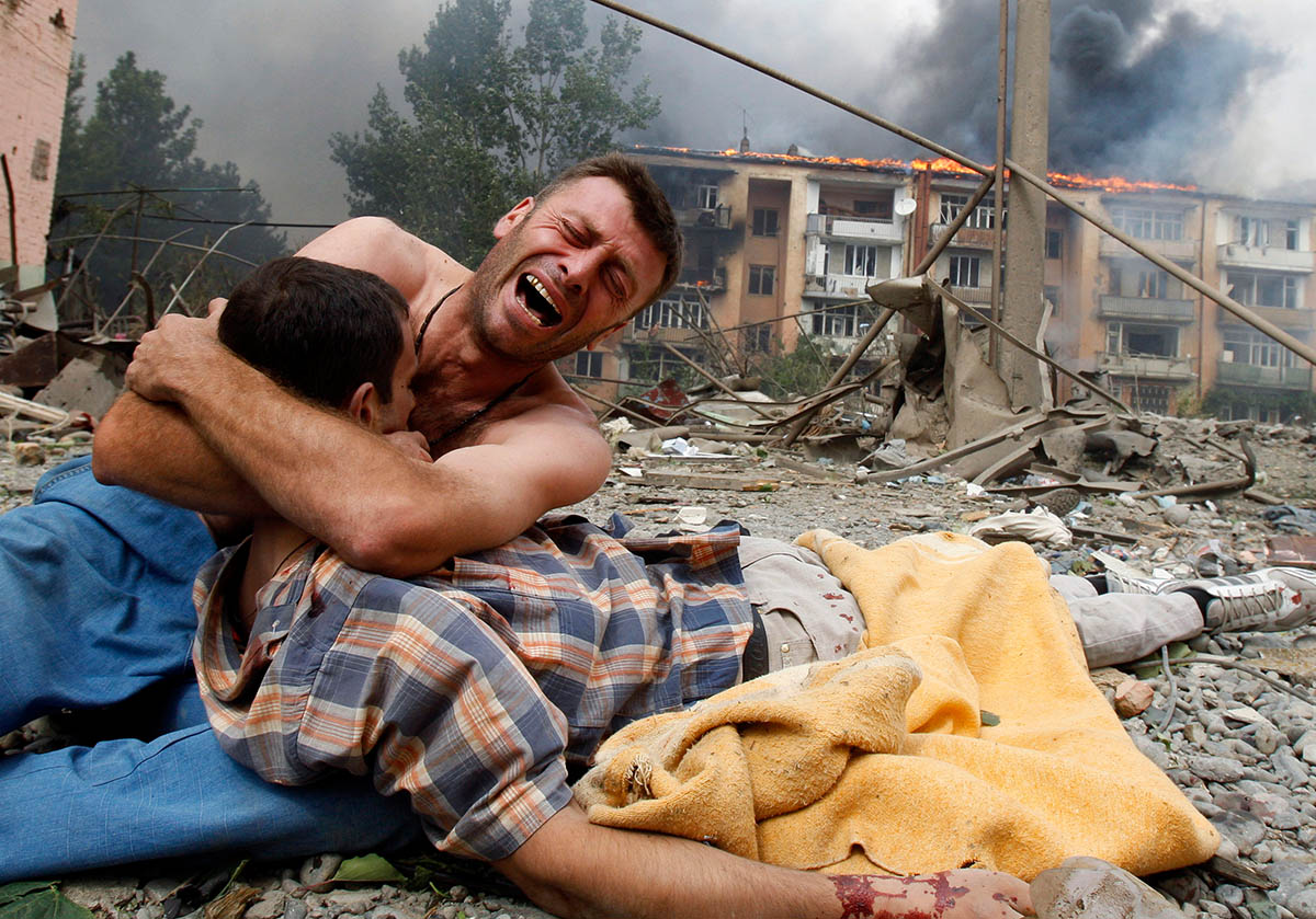 Грузинский мужчина плачет, держа тело своего родственника после обстрела в Гори, в 80 км от Тбилиси, 9 августа 2008 года. Фото Gleb Garanich/REUTERS/Scanpix/LETA