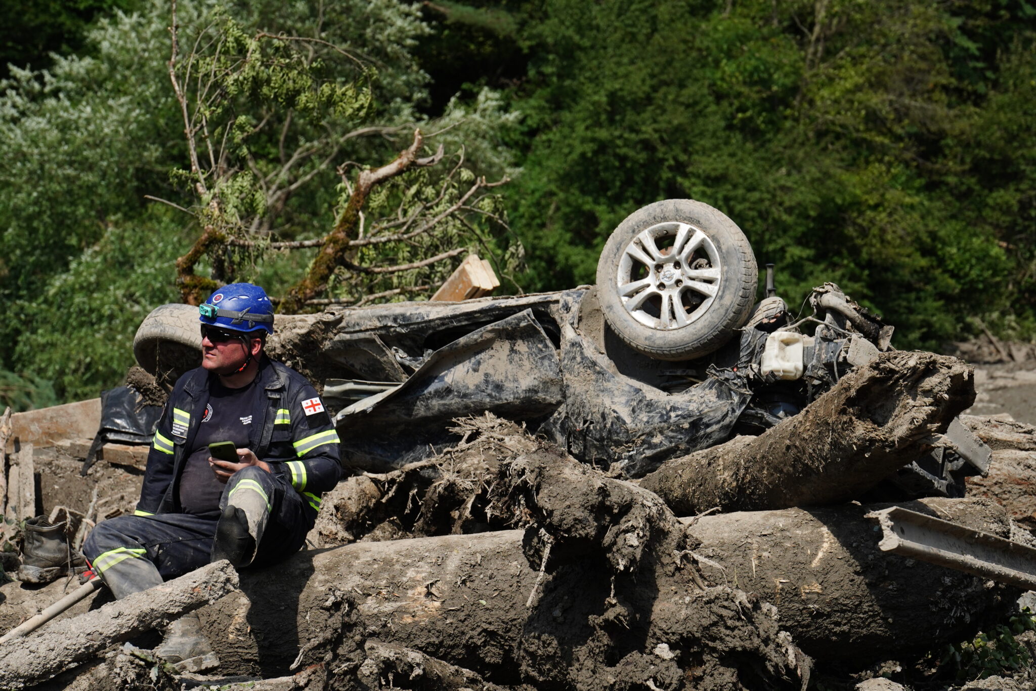 Грузинский спасатель возле уничтоженной машины в Шови. Фото Даниил Большаков/Spektr.Press
