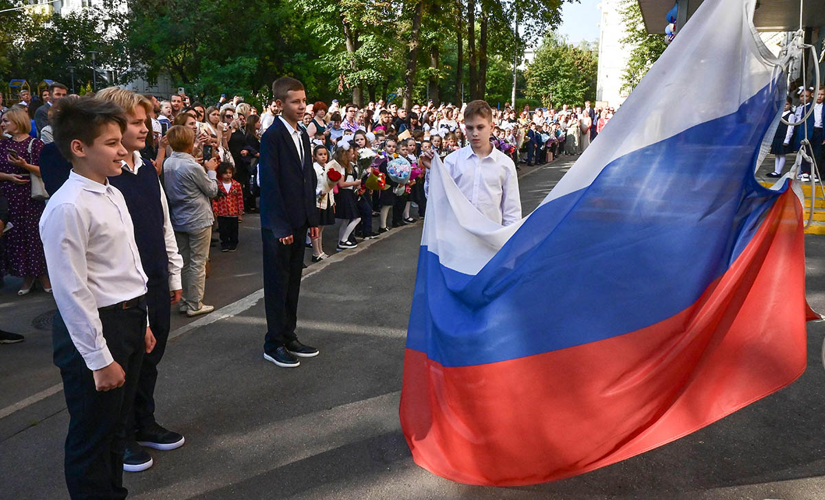 Российские школьники поднимают флаг, Москва, 1 сентября 2023 года. Фото Yuri KADOBNOV/AFP/Scanpix/LETA