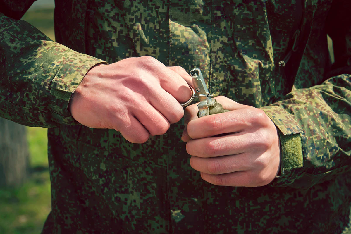 Солдат в камуфляже держит гранату. Иллюстративное фото Diy13 по лицензии istockphoto