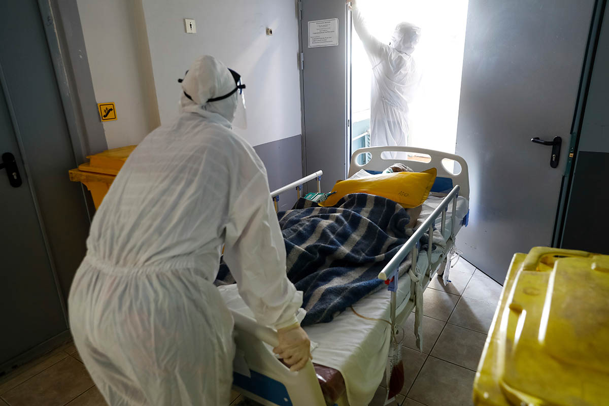 Медработники перевозят пациента с коронавирусом в отделение интенсивной терапии, Россия, 2021 год. Фото Alexandr Kulikov/AP Photo/Scanpix/Leta