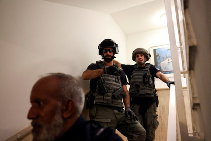Сотрудники израильских служб безопасности укрываются в укрытии во время пуска ракет из сектора Газа в Мевасерет-Ционе, Израиль, 7 октября 2023 года. Фото Ronen Zvulun/Reuters/Scanpix/LETA
