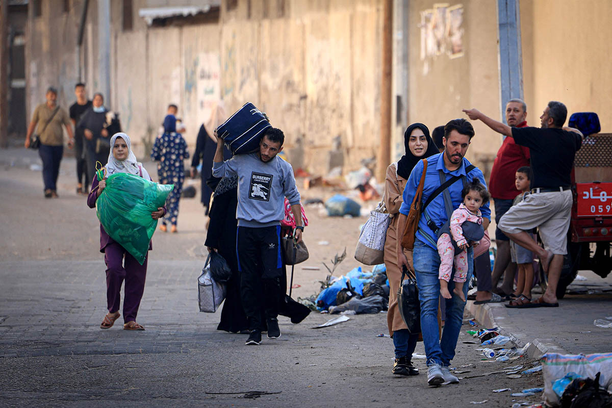 Палестинцы со своим имуществом идут в более безопасные районы города Газа после авиаударов Израиля, 13 октября 2023 года. Фото MAHMUD HAMS/AFP/Scanpix/LETA