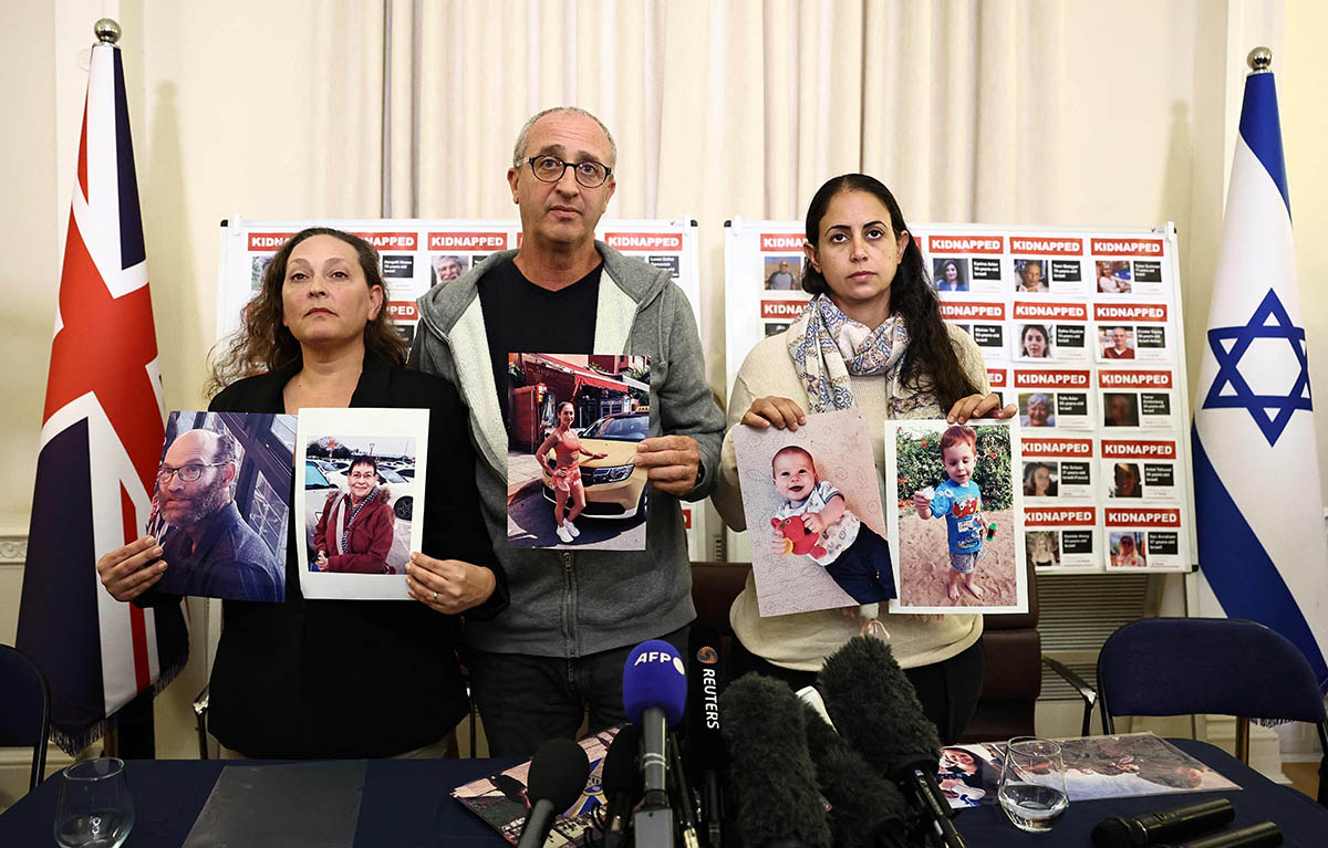 Родственники заложников и жертв теракта 7 октября в Израиле держат фотографии членов своей семьи во время пресс-конференции в посольстве Израиля в Лондоне, 24 октября 2023 года. Фото HENRY NICHOLLS/AFP/Scanpix/LETA