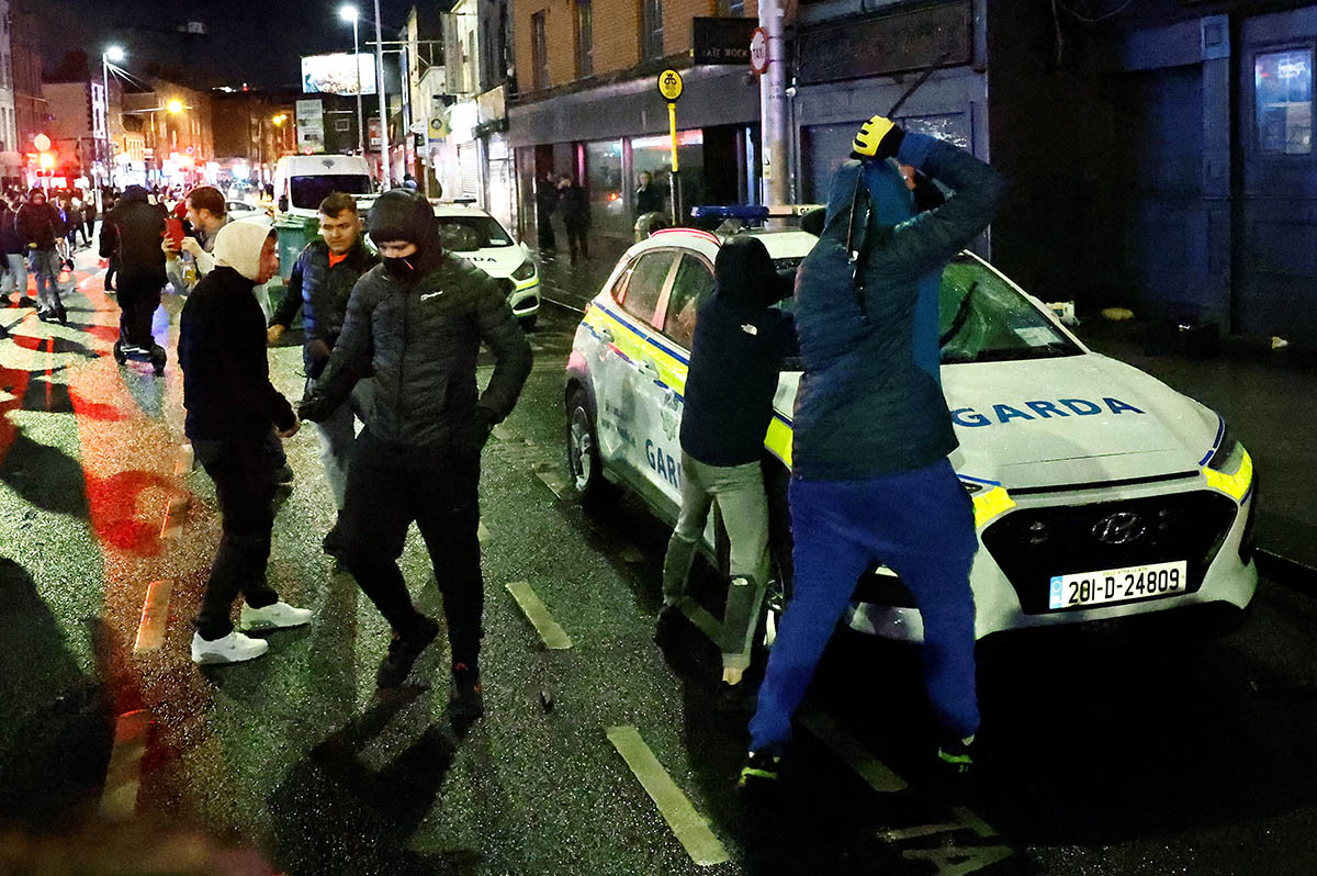 Протестующие громят полицейскую машину, 23 ноября 2023 года. Фото Clodagh Kilcoyne/REUTERS/Scanpix/LETA