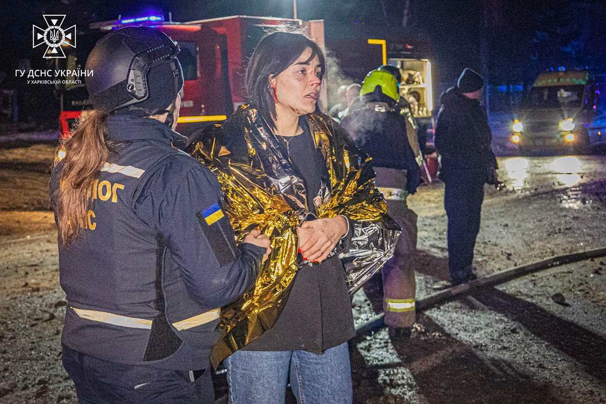 Спасатели помогают женщине после ночных российских ракетных ударов по гостинице в Харькове, 11 января 2024 года. Фото State Emergency Service of Ukraine/REUTERS/Scanpix/Leta