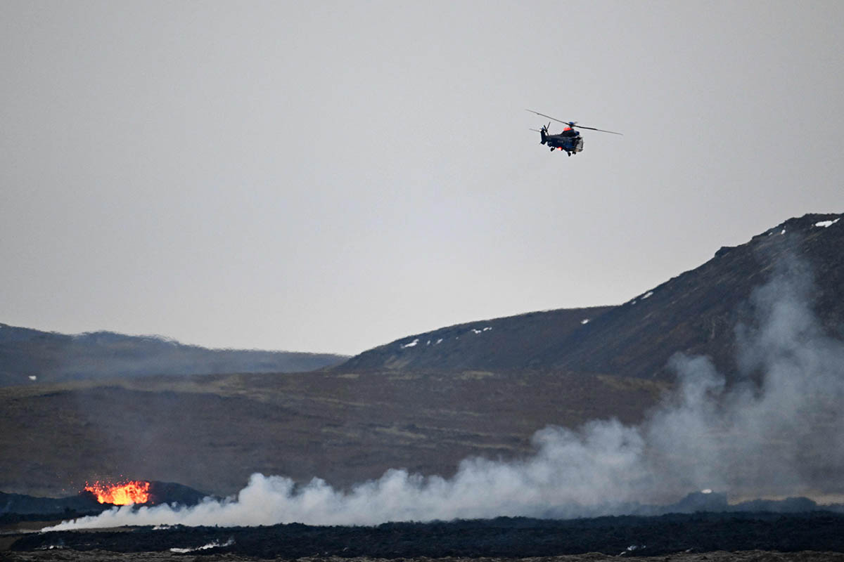 Вертолет исландской береговой охраны пролетает над Гриндавиком после извержения вулкана, 15 января 2024 года. Фото Halldor KOLBEINS/AFP/Scanpix/LETA