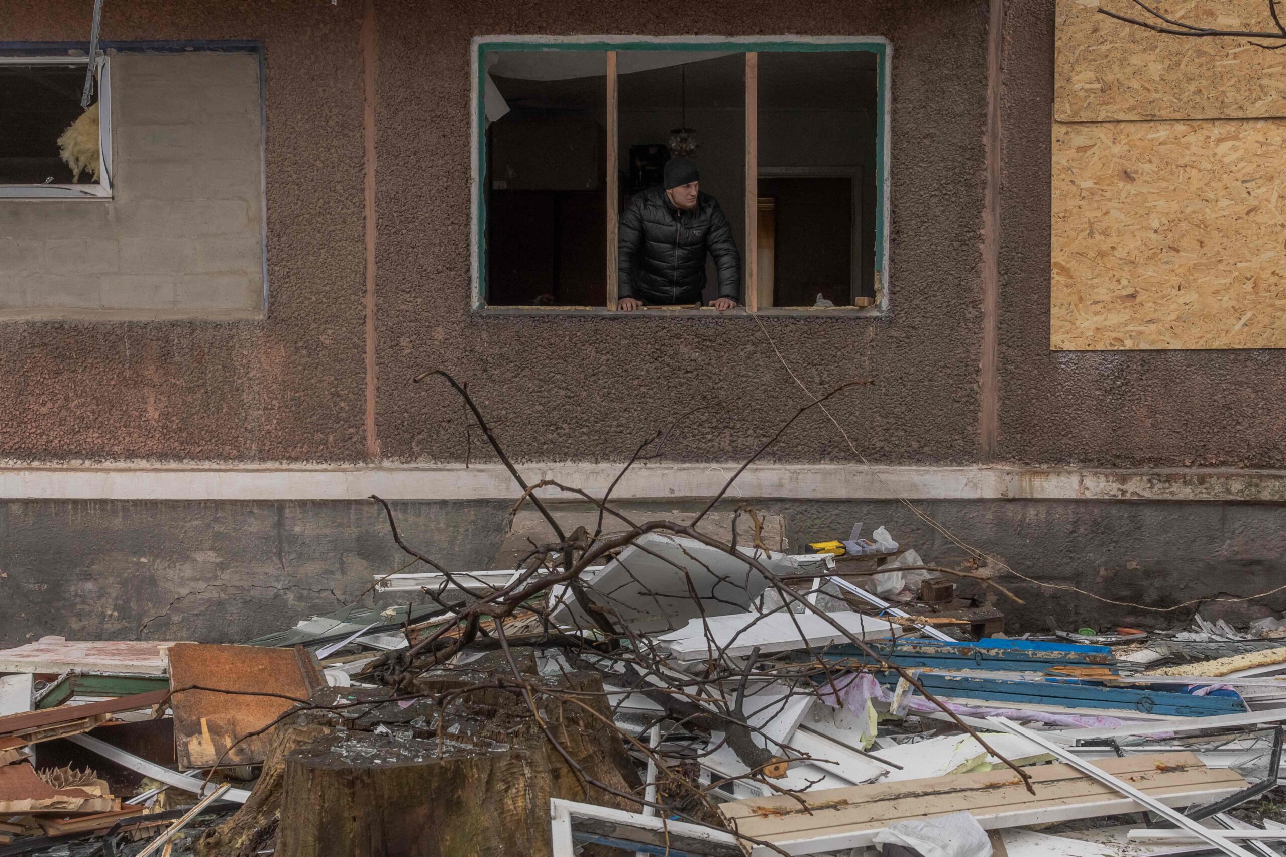 Мужчина стоит у окна своей поврежденной квартиры после ночного обстрела в Мирнограде Донецкой области 26 января 2024 года . Фото Roman Pilipey / AFP / Scanpix / LETA.