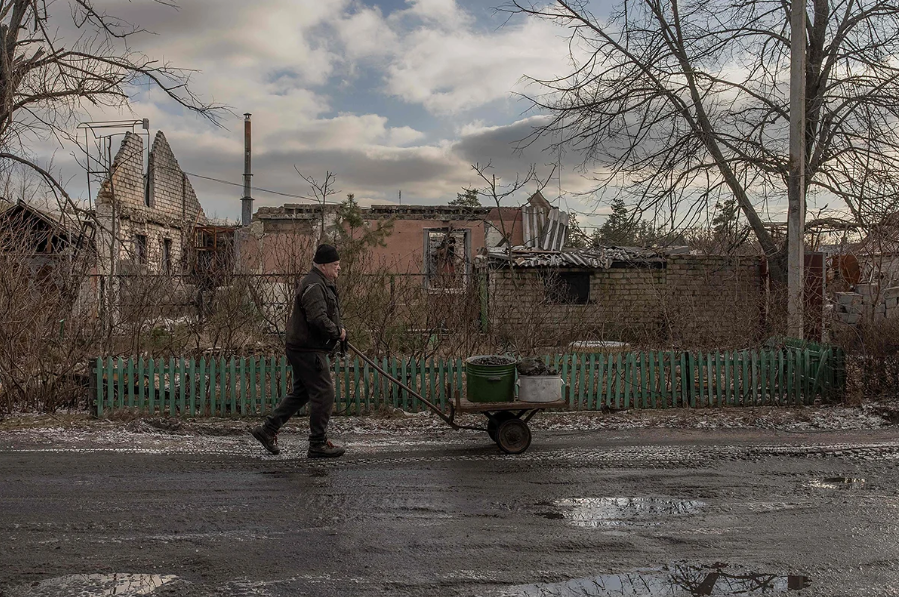 Местный житель Лимана идет с тележкой угля мимо разрушенных домов, Лиман Донецкая область, 21 января 2024 года. Фото: Роман Пилипей / AFP / Scanpix

