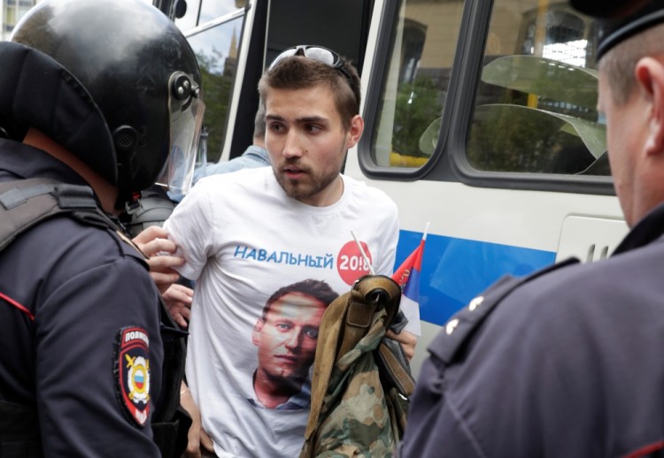 Riot police detain a man dressed in a t-shirt depicting opposition leader Alexei Navalny, during the Navalny-led anti-corruption protest in central Moscow, Russia, June 12, 2017. REUTERS/Tatyana Makeyeva