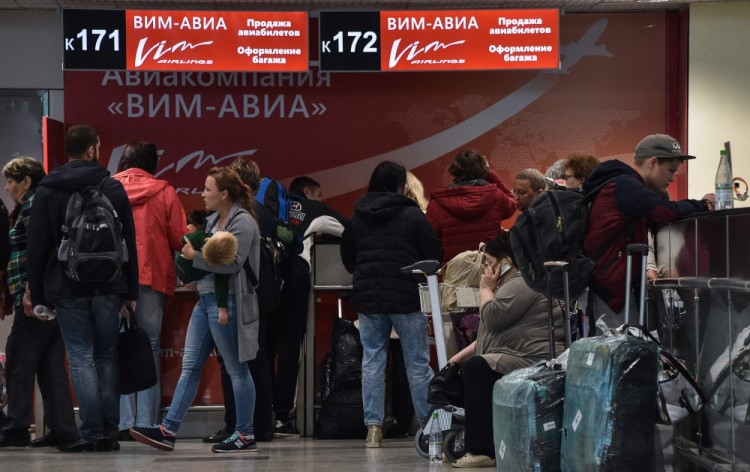 Passengers gather at a VIM-AVIA ticket desk at Moscow's Domodedovo airport on September 26, 2017. Tens of thousands of passengers were stranded on September 26, 2017 as the Russian private airline said it could no longer operate without state help and tour operators urged the government to avert an industry-wide crisis. / AFP PHOTO / Vasily MAXIMOV