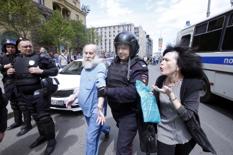 epa06024141 A woman speaks to a Russian police officer, who escorts a detained participant of an unauthorized opposition rally in Tverskaya  street in central Moscow, Russia, on Russia Day, 12 June 2017. Russian liberal opposition leader and anti-corruption blogger Alexei Navalny has called his supporters to hold a protest in Tverskaya Street, which leads to the Kremlin, instead of the authorized by Moscow officials Sakharov avenue. Changing the location may provoke  clashes with the police.  EPA/SERGEI CHIRIKOV
