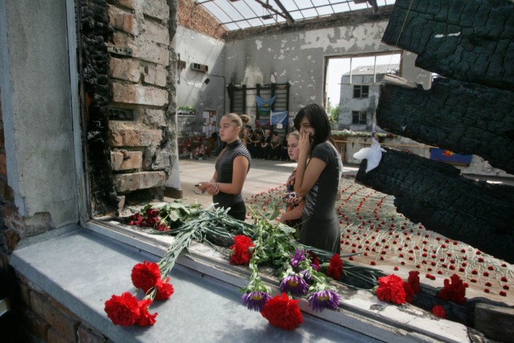 Teenage girls cry while walking through the Beslan school gymnasium on September 1, 2009 while commemorating the fifth anniversary of the 2004 terrorist hostage takeover that took the lives of over 330 people, including 186 children.  Five years on, Russian authorities have not learnt from the Beslan hostage siege, survivors of one of Russia's worst massacres in recent memory said as they marked its grim anniversary.           AFP PHOTO / KAZBEK BASAYEV