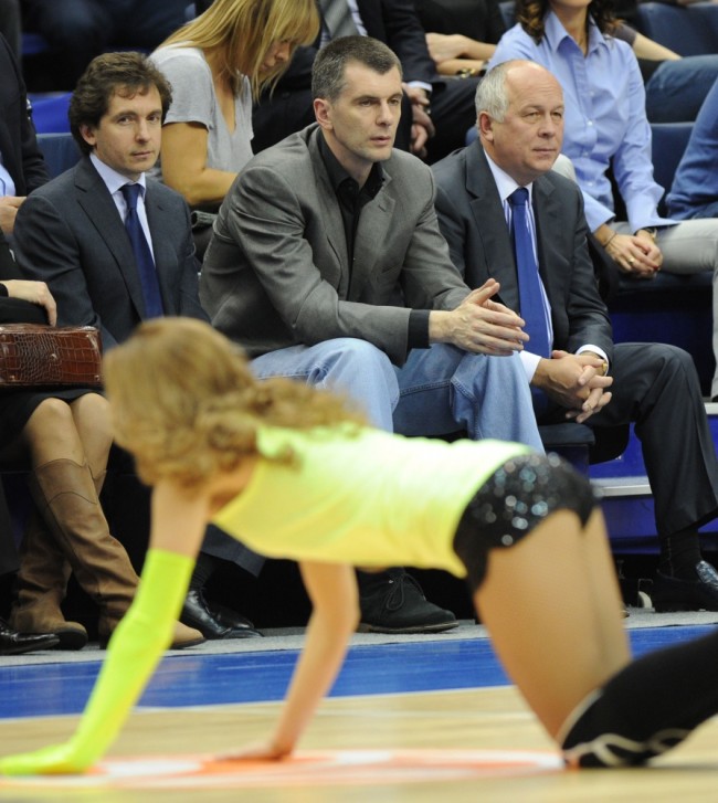 One of the presidential candidates, Russian metals tycoon and US basketball team owner, Mikhail Prokhorov (C) sits in the stands while a cheerleader performs during the Euroleague Basketball top 16 match CSKA Moscow and Olympiacos in Moscow on February 22, 2012. Prokhorov challenges Prime Minister Vladimir Putin in the March 2012 presidential polls. CSKA Moscow won 96-64.  AFP PHOTO/YURI KADOBNOV