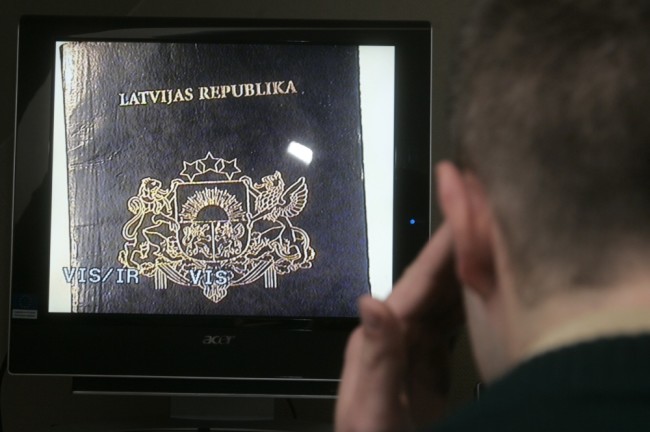 Латвийский пограничник проверяет паспорт на границе с Россией. Фото: Reuters / Scanpix