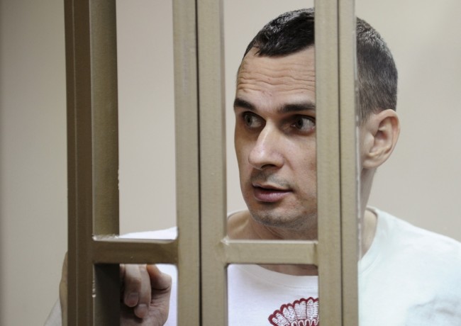 Ukrainian film director Oleg Sentsov looks on from a defendants' cage as he attends a court hearing in Rostov-on-Don, Russia, August 25, 2015. A Russian court on Tuesday sentenced Sentsov to 20 years in a high-security penal colony for 